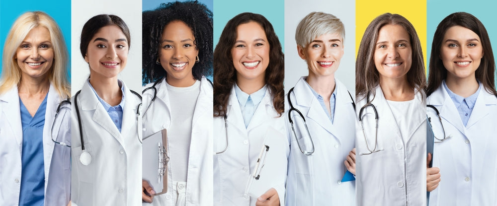 Group of diverse female doctors in lab coats with stethoscopes, smiling against colorful backgrounds.