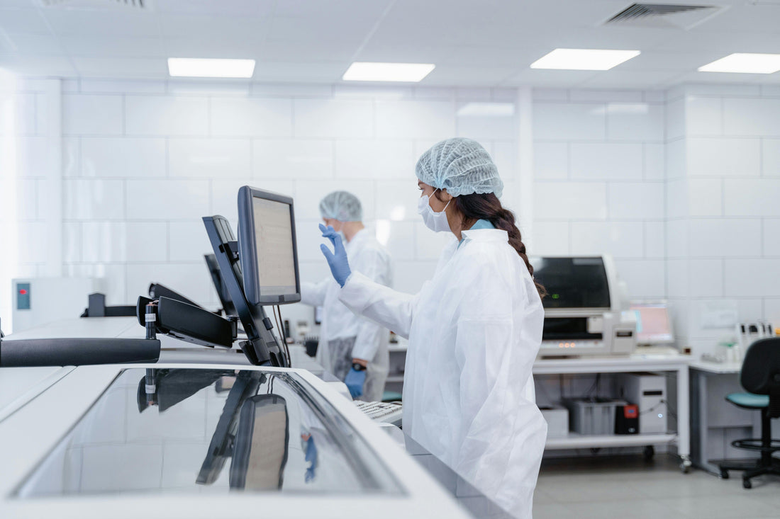 Medical lab technician in PPE using a computer in a modern laboratory setting