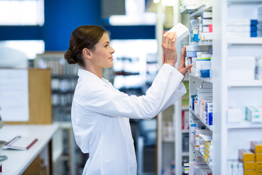 Pharmacist organizing medical supplies on pharmacy shelves