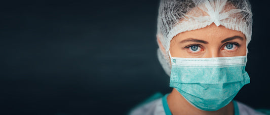 Healthcare worker wearing surgical mask and hair net, close-up, medical supplies concept