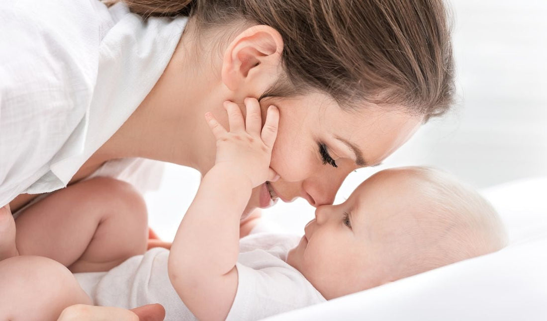 Mother cuddling newborn baby, close up, parenting and infant care concept