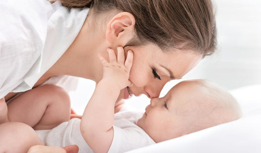 Mother cuddling newborn baby, close up, parenting and infant care concept