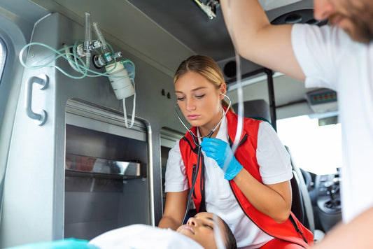 Paramedic in ambulance performing emergency care on patient with medical equipment