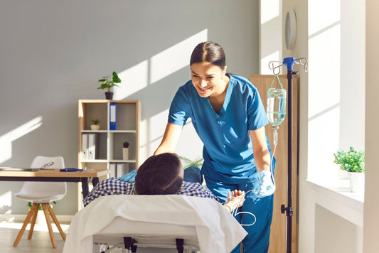Nurse administering IV therapy to patient in bright, modern medical clinic