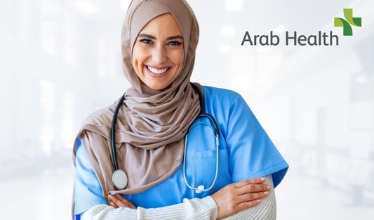 Smiling female healthcare worker in blue scrubs and hijab with stethoscope in hospital setting