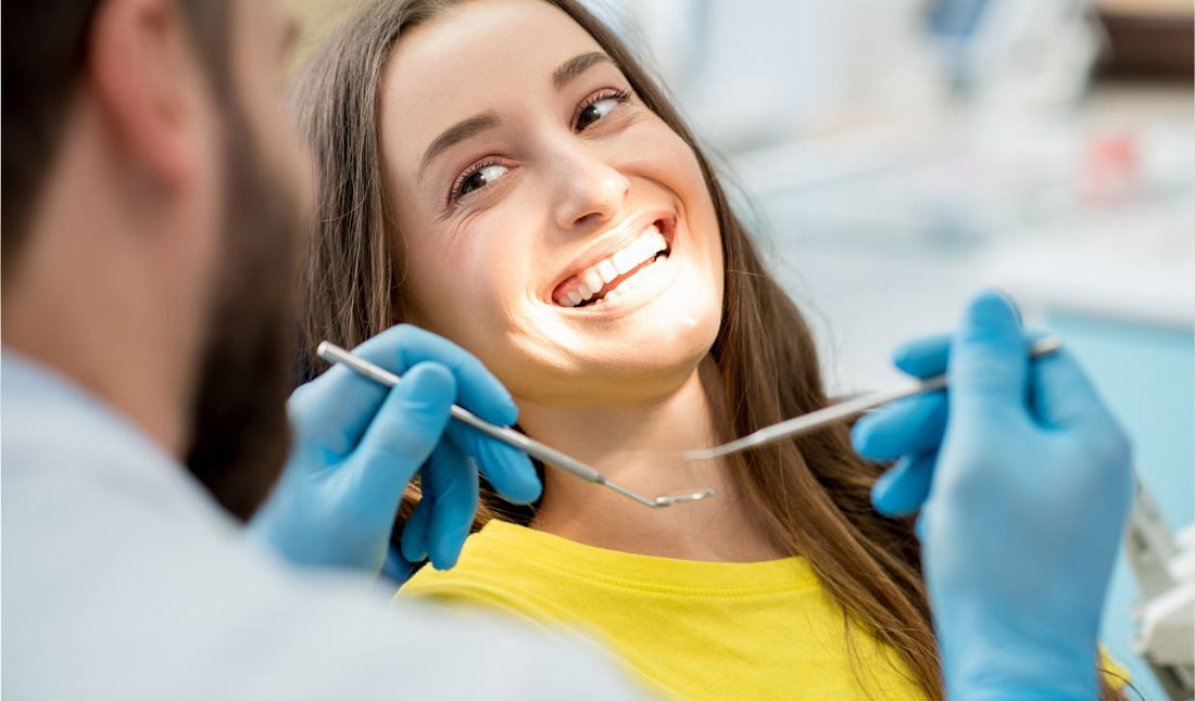 Smiling woman in dental clinic, dentist with blue gloves using dental tools