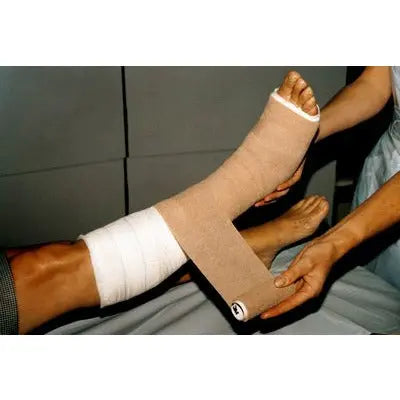 3M Coban self-adherent bandage in flesh color, 10cm x 4.5m, shown in box of 18, used for wound compression and support.
