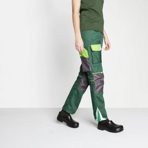 Person wearing green medical work trousers with cargo pockets and black safety shoes