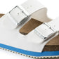 Close-up of white sandal with silver buckles, cork footbed, and blue non-slip sole