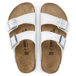 White leather double strap sandals with buckles and cork footbed, top view