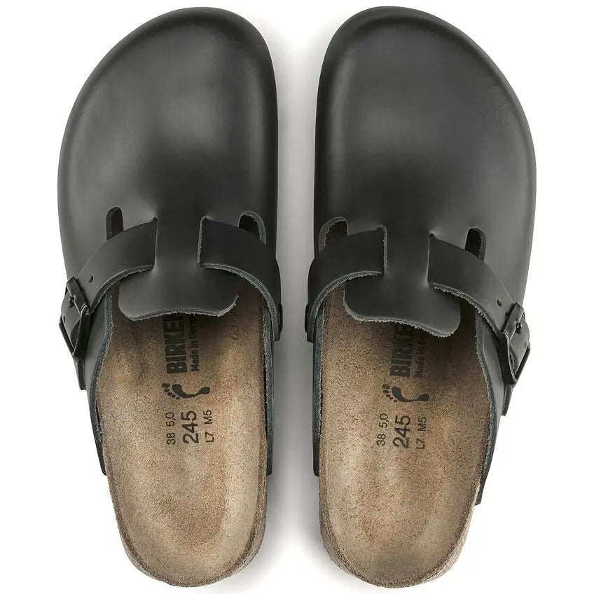Pair of black closed-toe clogs with buckles and contoured footbeds, top view
