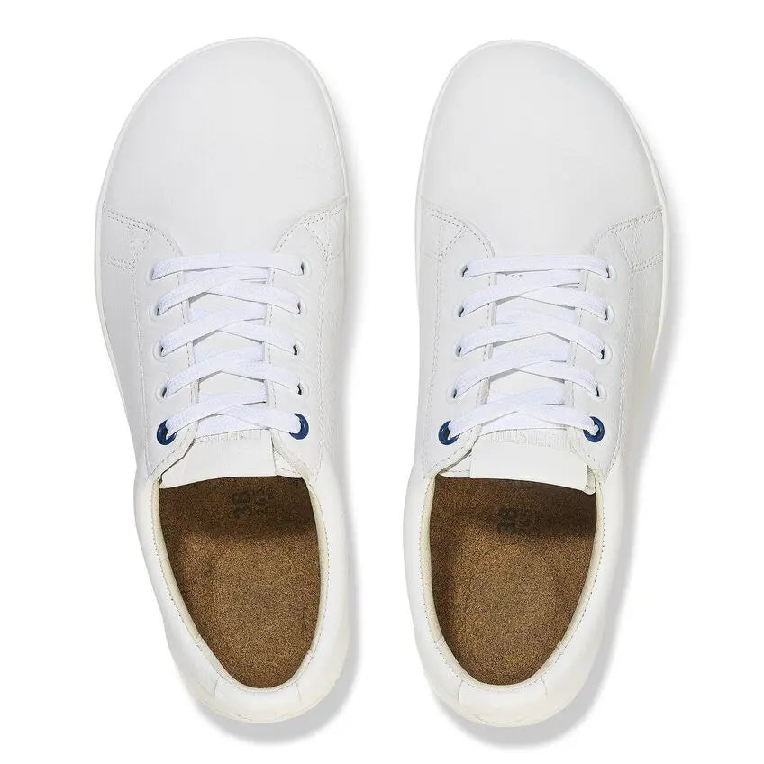 Pair of white lace-up shoes with cork insoles, top view on white background