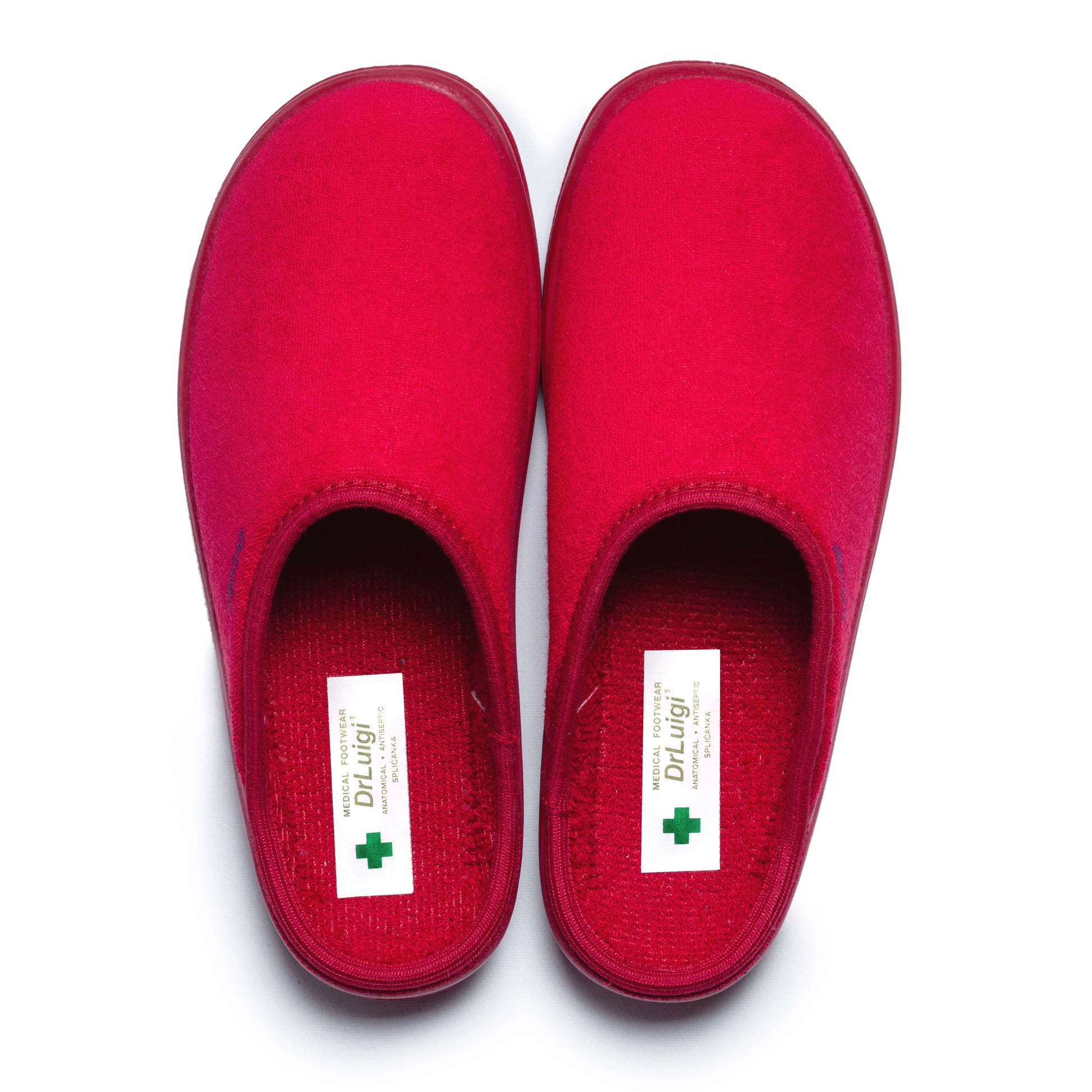 Pair of red medical orthopedic slippers with closed toe on white background