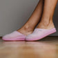 Pink orthopedic slippers on wooden floor, comfortable indoor footwear for women