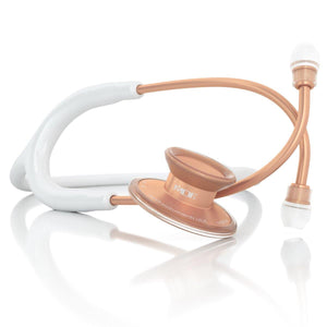 Acoustica MDF Instruments stethoscope in white with rose gold accents, featuring adjustable binaurals and dual-sided chest piece.