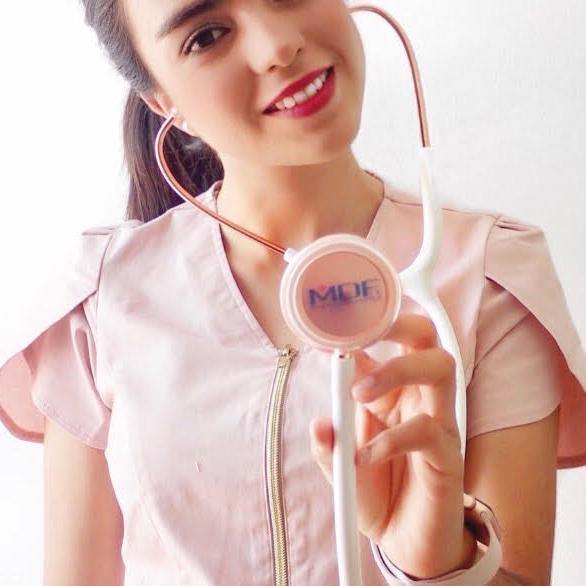 MDF Instruments Acoustica® Stethoscope in white with rose gold accents, shown in a lifestyle setting.