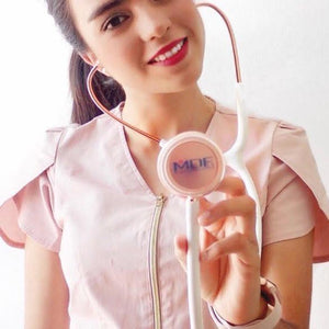 MDF Instruments Acoustica® Stethoscope in white with rose gold accents, shown in a lifestyle setting.