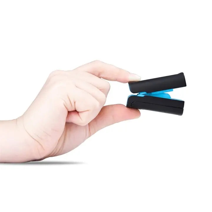Hand holding a black fingertip pulse oximeter with blue interior on white background