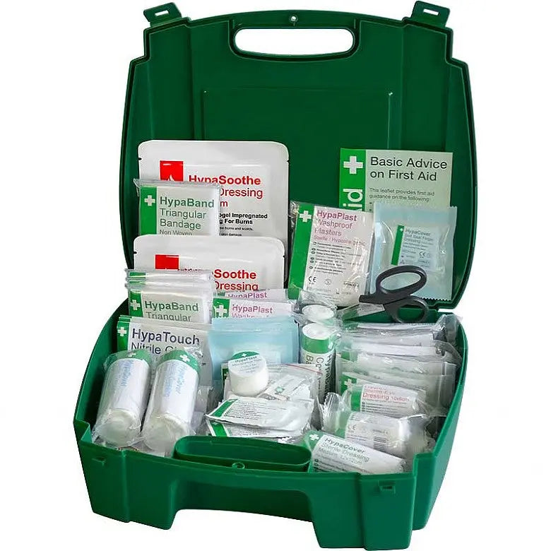 Green first aid kit open with bandages, plasters, dressings, gloves, and scissors visible