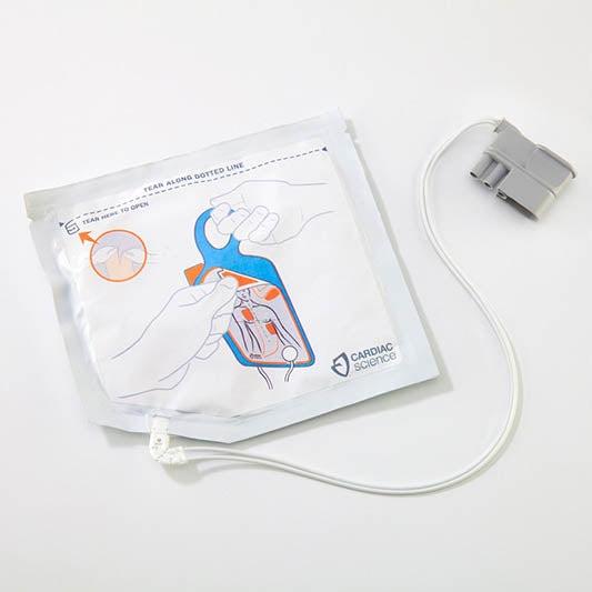 Zoll Cardiac Science Powerheart G5 pediatric defibrillator pads attached to a child's chest for emergency cardiac treatment.